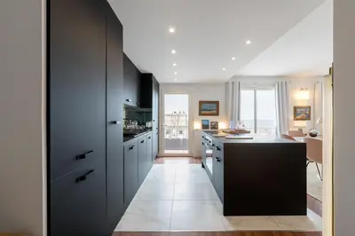 a kitchen with black cabinets and a black counter at Geoffrey By Terrys Homes in Cannes