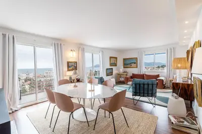 a living room with a table and chairs at Geoffrey By Terrys Homes in Cannes