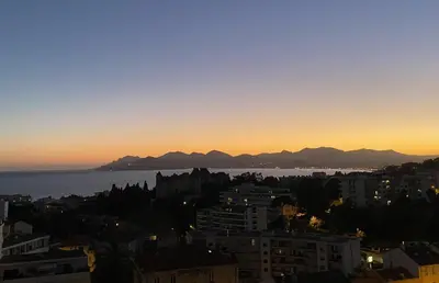 a view of the city and the ocean at sunset at Geoffrey By Terrys Homes in Cannes