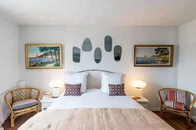a bedroom with a white bed and two chairs at Geoffrey By Terrys Homes in Cannes