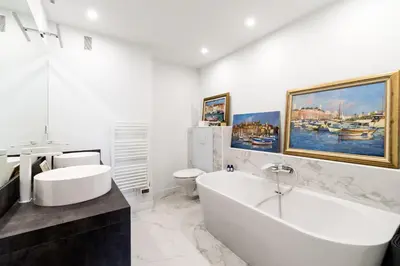 a white bathroom with a tub and a sink at Geoffrey By Terrys Homes in Cannes