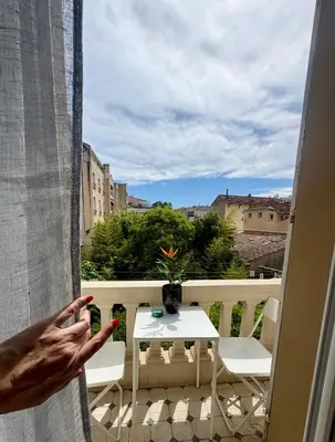 a person looking out the window of a balcony at Cannes Central Balcony- 9 min Festival in Cannes