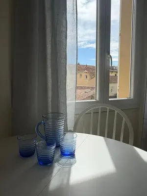 four blue glasses sitting on a table in front of a window at Cannes Central Balcony- 9 min Festival in Cannes