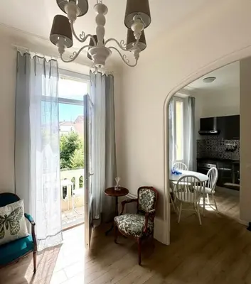 a living room with a chandelier and a table and chairs at Cannes Central Balcony- 9 min Festival in Cannes