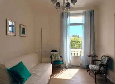 a living room with a couch and a window at Cannes Central Balcony- 9 min Festival in Cannes