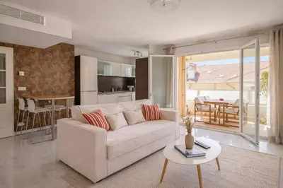 a living room with a white couch and a table at Apt Lumineux avec Terrasse à 5' du Centre in Cannes