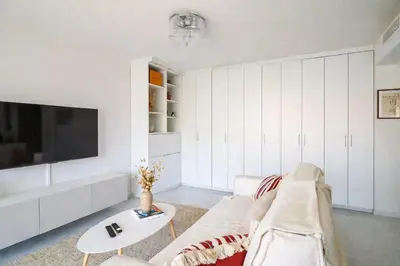 a living room with a couch and a tv at Apt Lumineux avec Terrasse à 5' du Centre in Cannes