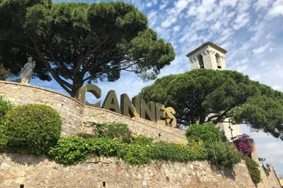 a statue on top of a wall with a clock tower at Bright and vast studio terrace easy parking Cannes heart of town 1 mn in Cannes