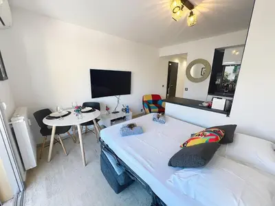 a bedroom with a bed and a small table at Bright and vast studio terrace easy parking Cannes heart of town 1 mn in Cannes