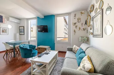 a living room with a couch and a table at LE MIROIR D'ANDRÉ séjour de bonheur au cœur de Cannes in Cannes