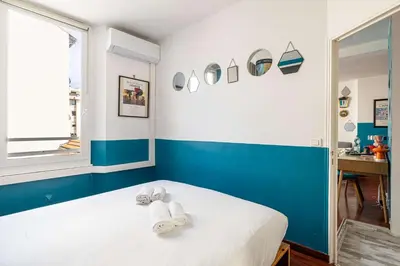 a blue and white bedroom with towels on a bed at LE MIROIR D'ANDRÉ séjour de bonheur au cœur de Cannes in Cannes