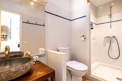 a bathroom with a sink and a toilet and a shower at LE MIROIR D'ANDRÉ séjour de bonheur au cœur de Cannes in Cannes