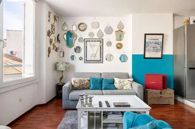 a living room with a couch and a table at LE MIROIR D'ANDRÉ séjour de bonheur au cœur de Cannes in Cannes