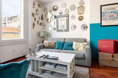 a living room with a couch and a table at LE MIROIR D'ANDRÉ séjour de bonheur au cœur de Cannes in Cannes