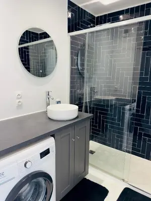 a bathroom with a washing machine and a sink at Apartement 2 pièces in Le Cannet