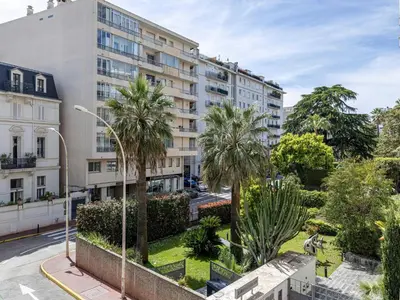 an apartment building with palm trees in a city at Elegant apartment - AC-4P - Cannes in Cannes