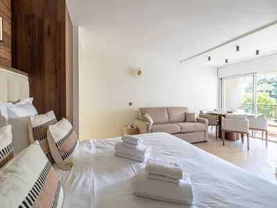 a white bedroom with a large bed and a living room at Elegant apartment - AC-4P - Cannes in Cannes