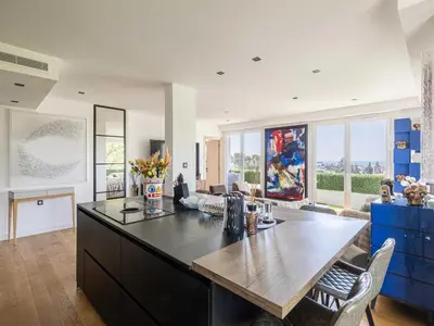 a kitchen with a table and a living room at Modern flat with sea view - AC- 2BR- 4P - Cannes in Cannes