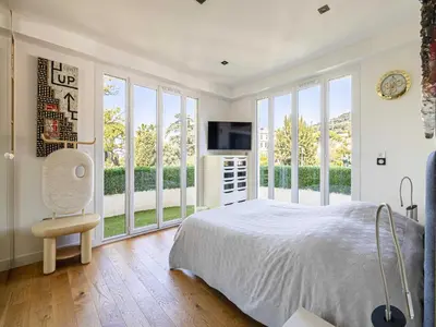 a bedroom with a bed and a tv and windows at Modern flat with sea view - AC- 2BR- 4P - Cannes in Cannes