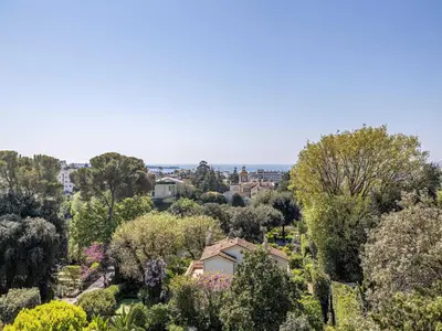 a view of a garden with trees and houses at Modern flat with sea view - AC- 2BR- 4P - Cannes in Cannes
