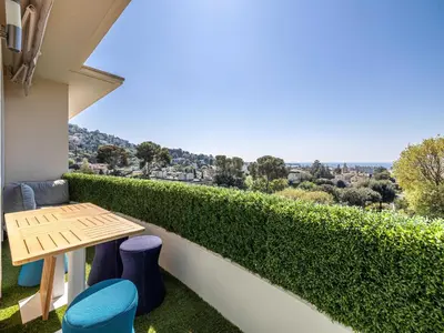 a balcony with a table and chairs and a view at Modern flat with sea view - AC- 2BR- 4P - Cannes in Cannes