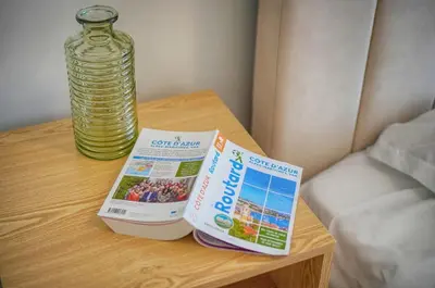 a table with a book and a bottle of water at ISABELLE New spacious 3BR Apt AC in Cannes