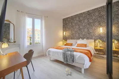 a bedroom with a large bed and a desk at Emily 2 bedrooms 2 baths near Palais in Cannes