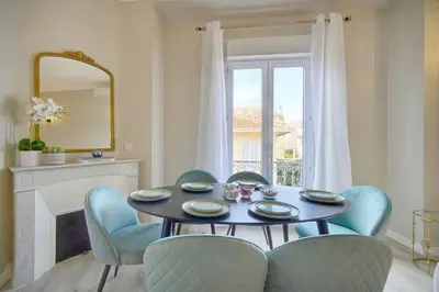 a dining room with a table and chairs and a mirror at Emily 2 bedrooms 2 baths near Palais in Cannes