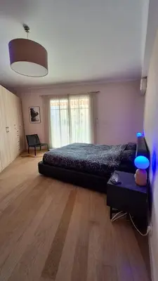 a bedroom with a bed and a table with a lamp at Spacieux et lumineux 2 chambres terrasse in Le Cannet