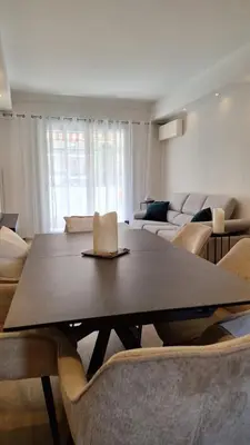 a living room with a table and some chairs at Spacieux et lumineux 2 chambres terrasse in Le Cannet
