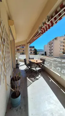 a patio with a table and chairs on a balcony at Spacieux et lumineux 2 chambres terrasse in Le Cannet