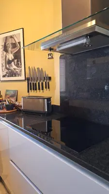 a kitchen with a black counter top with knives at Spacieux et lumineux 2 chambres terrasse in Le Cannet
