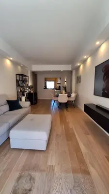 a living room with a white couch and a tv at Spacieux et lumineux 2 chambres terrasse in Le Cannet