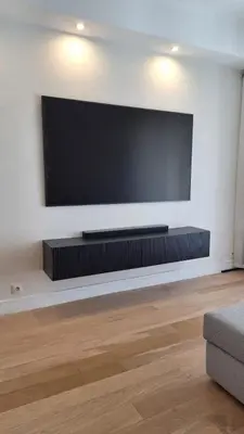 a living room with a large flat screen tv on a wall at Spacieux et lumineux 2 chambres terrasse in Le Cannet
