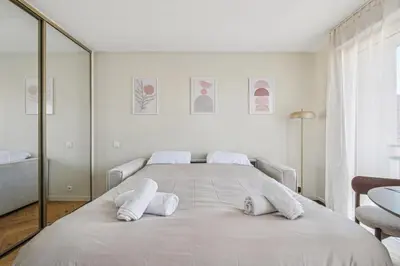 a white bedroom with a large bed with white pillows at Cozy Cannes in Cannes