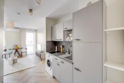 a kitchen with white cabinets and a washer and dryer at Cozy Cannes in Cannes