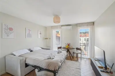 a bedroom with a bed and a table and a window at Cozy Cannes in Cannes