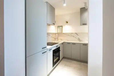 a white kitchen with white cabinets and appliances at Maison Azur-Townhouse Cannes Near Palais in Cannes