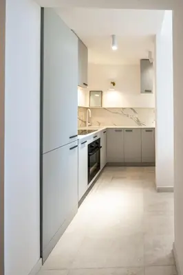 an empty kitchen with white cabinets and appliances at Maison Azur-Townhouse Cannes Near Palais in Cannes