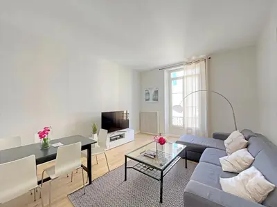 a living room with a blue couch and a table at IRIS APARTMENT backCroisette in Cannes
