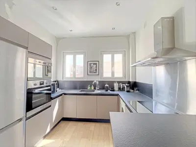 a kitchen with stainless steel appliances and a wooden floor at IRIS APARTMENT backCroisette in Cannes