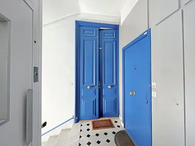 a blue door in a hallway with a checkered floor at IRIS APARTMENT backCroisette in Cannes