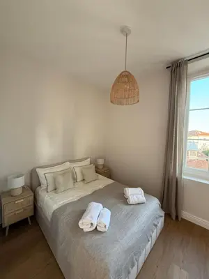 a bedroom with a bed with two towels on it at Maison Dalaise - Cannes in Cannes