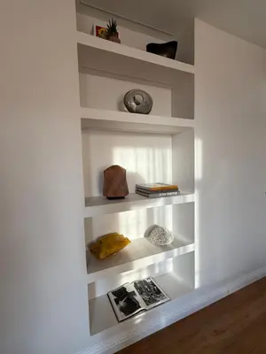 a book shelf with books and a clock on it at Maison Dalaise - Cannes in Cannes