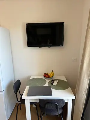 a small room with a table and a tv on the wall at Shiny Sea View Flat vue merTerrace in Cannes in Cannes
