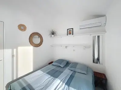 a bedroom with a bed in a white room at Appartement Cannes vue sur mer in Cannes