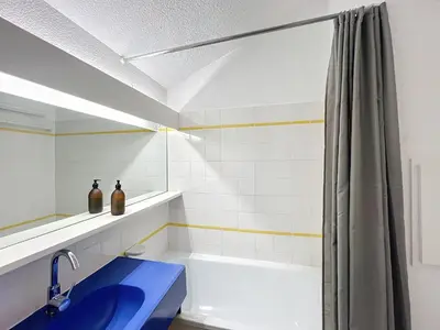 a bathroom with a shower and a blue sink at Appartement Cannes vue sur mer in Cannes