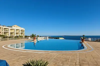 a swimming pool with the ocean in the background at Appartement Cannes vue sur mer in Cannes