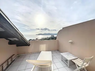 a balcony with a table and chairs on a building at Appartement Cannes vue sur mer in Cannes