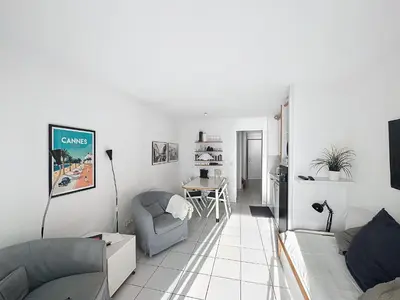 a living room with two couches and a table at Appartement Cannes vue sur mer in Cannes